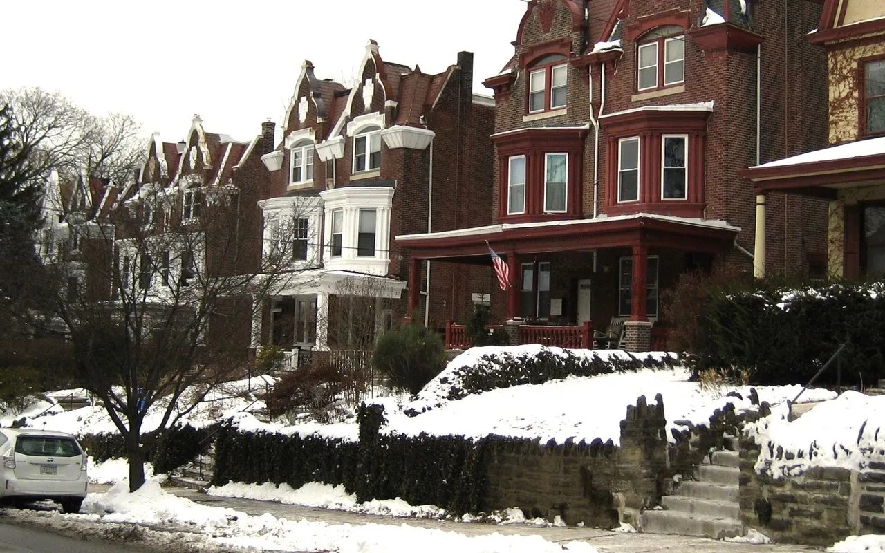 Brick twin houses with gabled fronts and porches on Mount Pleasant Avenue in winter