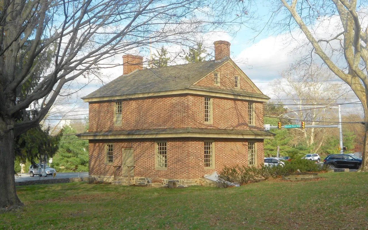 The Square Tavern, a two-story 1742 brick building on a lawn at the corner of Newtown Street and Goshen roads, framed by bare trees