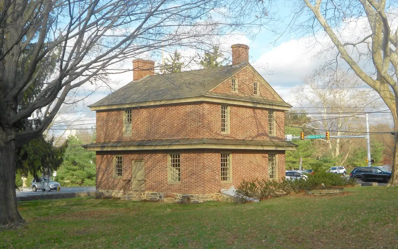 The Square Tavern, a two-story 1742 brick building on a lawn at the corner of Newtown Street and Goshen roads, framed by bare trees
