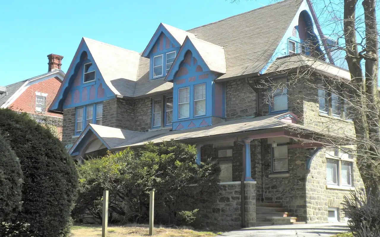 A stone Overbrook Farms house with steep gables and a wide porch